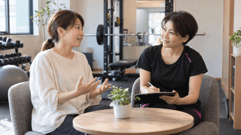 女性トレーナーに笑顔で相談する